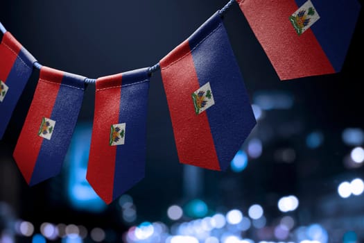 A garland of Haiti national flags on an abstract blurred background.