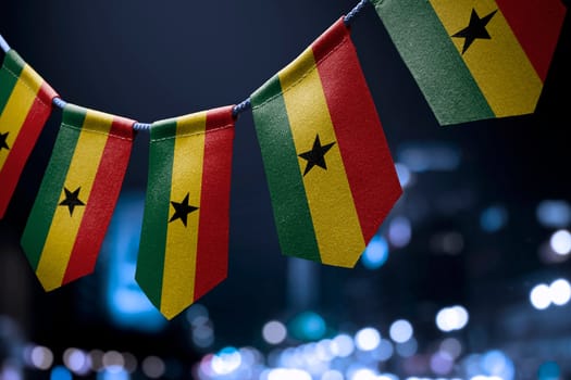 A garland of Ghana national flags on an abstract blurred background.