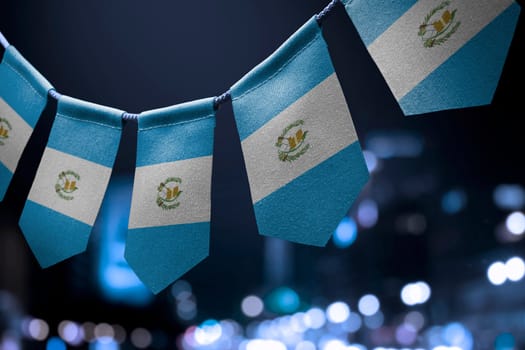 A garland of Guatemala national flags on an abstract blurred background.