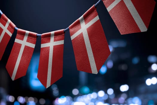 A garland of Denmark national flags on an abstract blurred background.
