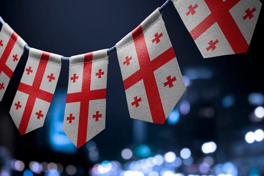 A garland of Georgia national flags on an abstract blurred background.