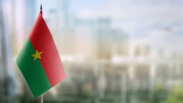 Small flags of the Burkina Faso on an abstract blurry background.