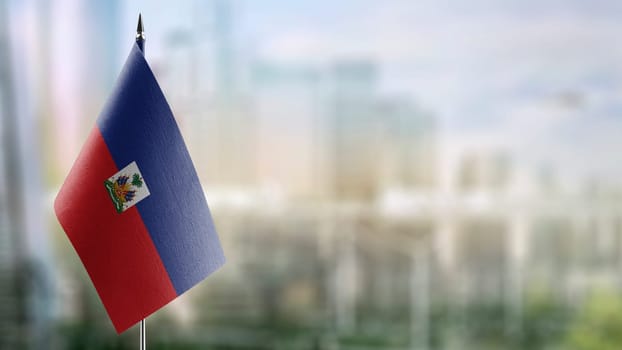 Small flags of the Haiti on an abstract blurry background.