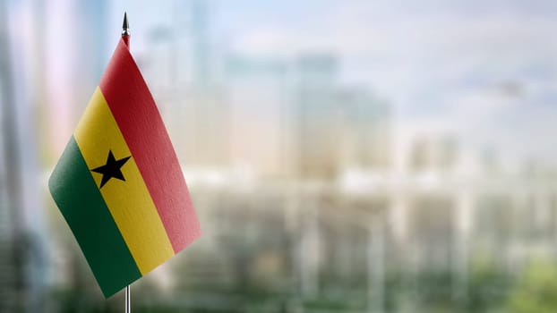 Small flags of the Ghana on an abstract blurry background.