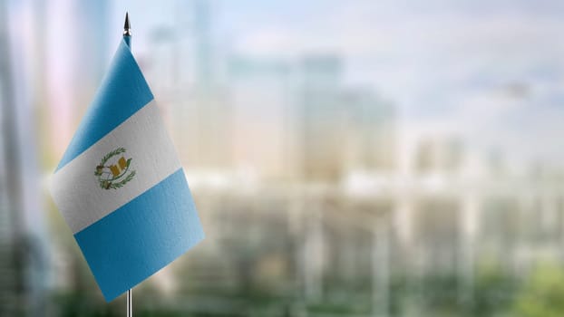 Small flags of the Guatemala on an abstract blurry background.