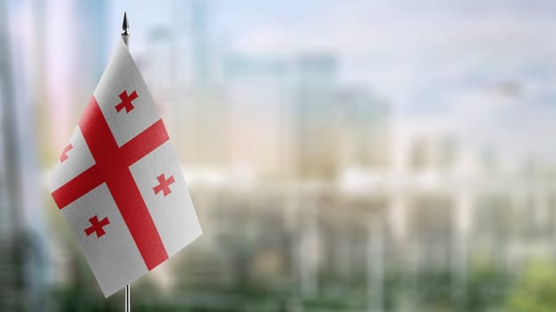 Small flags of the Georgia on an abstract blurry background.