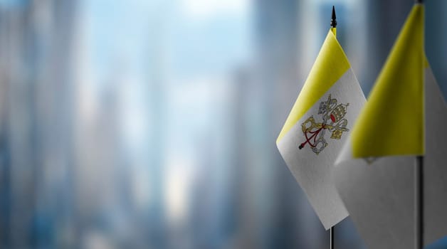 Small flags of the Vatican on an abstract blurry background.