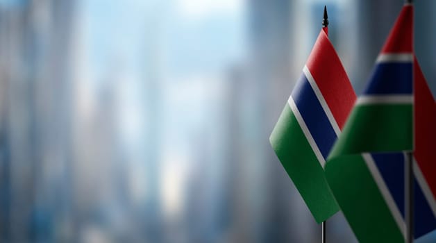 Small flags of the Gambia on an abstract blurry background.
