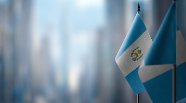 Small flags of the Guatemala on an abstract blurry background.
