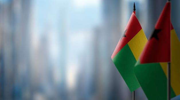 Small flags of the Guinea Bissau on an abstract blurry background.