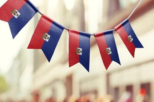 A garland of Haiti national flags on an abstract blurred background.