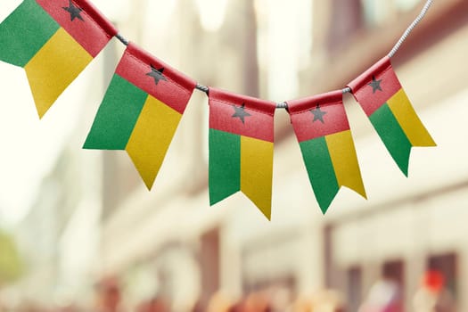 A garland of Guinea Bissau national flags on an abstract blurred background.