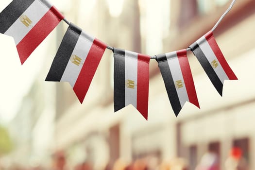 A garland of Egypt national flags on an abstract blurred background.
