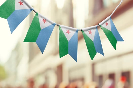 A garland of Djibouti national flags on an abstract blurred background.