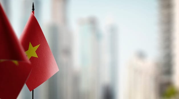 Small flags of the Vietnam on an abstract blurry background.