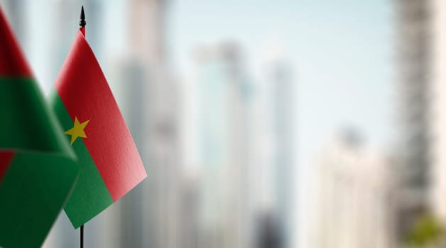 Small flags of the Burkina Faso on an abstract blurry background.