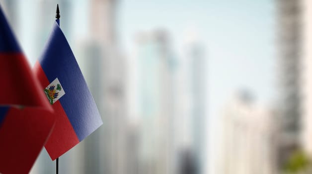Small flags of the Haiti on an abstract blurry background.