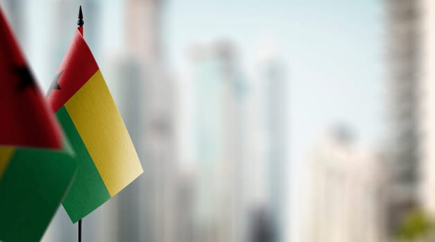 Small flags of the Guinea Bissau on an abstract blurry background.