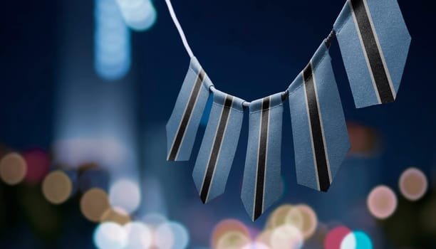 A garland of Botswana national flags on an abstract blurred background.