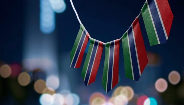 A garland of Gambia national flags on an abstract blurred background.