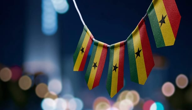 A garland of Ghana national flags on an abstract blurred background.