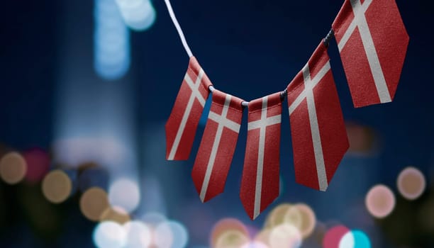 A garland of Denmark national flags on an abstract blurred background.