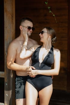 guy and a girl in bathing suits are relaxing, sunbathing and having fun near the blue pool