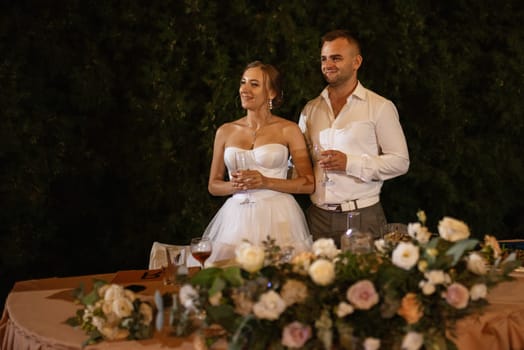 portrait of the newlyweds at the presidium at the wedding banquet