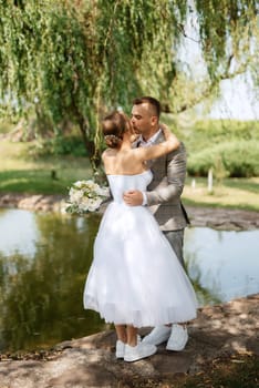 the first meeting of the bride and groom in wedding outfits in the park