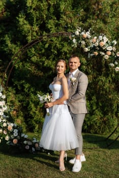 wedding ceremony of the newlyweds on the glade near the restaurant