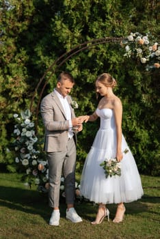 wedding ceremony of the newlyweds on the glade near the restaurant