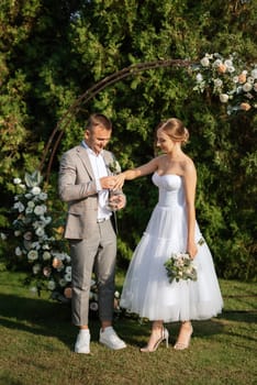 wedding ceremony of the newlyweds on the glade near the restaurant