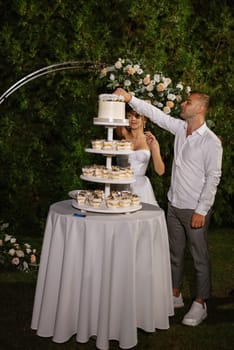 newlyweds happily cut, laugh and taste the wedding cake