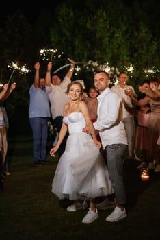 newlyweds at a wedding in the corridor of sparklers