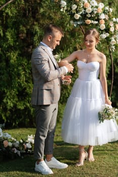 wedding ceremony of the newlyweds on the glade near the restaurant