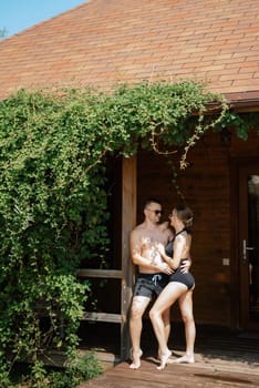 guy and a girl in bathing suits are relaxing, sunbathing and having fun near the blue pool