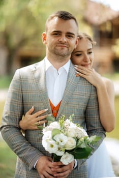 the first meeting of the bride and groom in wedding outfits in the park