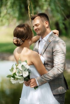 the first meeting of the bride and groom in wedding outfits in the park