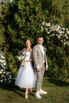 wedding ceremony of the newlyweds on the glade near the restaurant