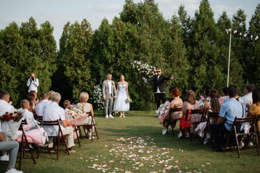 wedding ceremony of the newlyweds on the glade near the restaurant