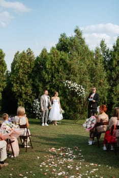 wedding ceremony of the newlyweds on the glade near the restaurant