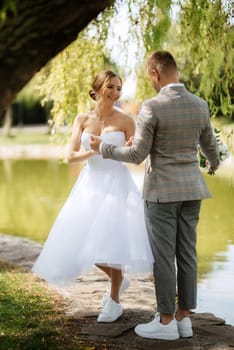 the first meeting of the bride and groom in wedding outfits in the park