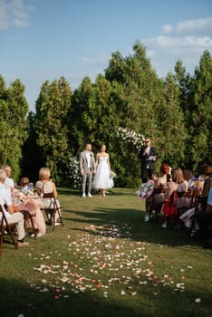 wedding ceremony of the newlyweds on the glade near the restaurant