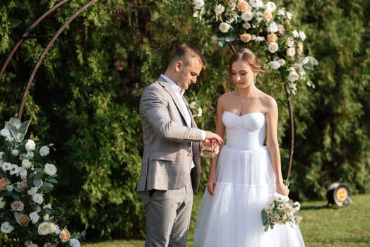 wedding ceremony of the newlyweds on the glade near the restaurant