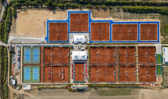 Aerial view of empty clay tennis court on a sunny day