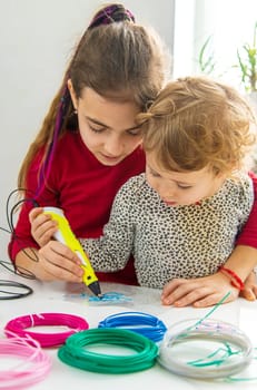 Child 3D drawings with a pen on the table. Selective focus. Kid.