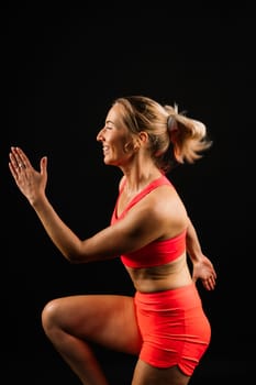 Beautiful female with dumbbells posing on a studio background