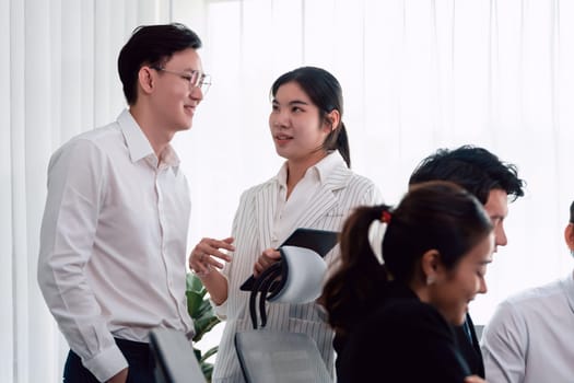 Mentor, manager advice younger colleagues in workplace. Businesspeople discussing or planning financial project strategy, talking together for harmony and strong teamwork in office concept.