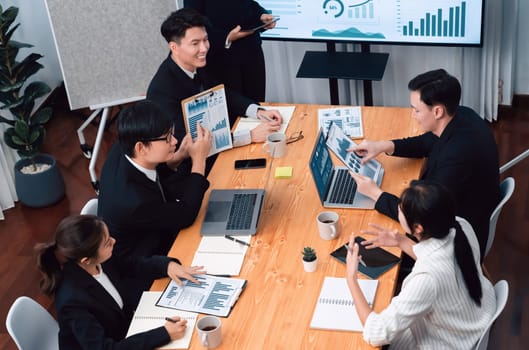 Top widen view of confidence of company presentation on financial analyzed by business intelligence in dashboard report with businesspeople in boardroom meeting to promote harmony in workplace concept