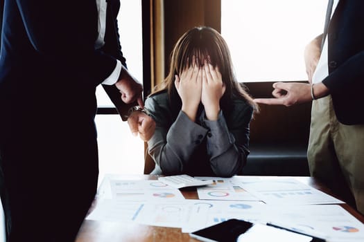 Portrait of a female worker showing failure at work and being reprimanded by a colleague.